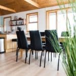 Modern kitchen and dining area with natural wood finishes and black chairs, ideal for contemporary home decor and gatherings.