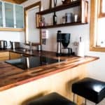 Warm wood kitchen interior with coffee maker, kettle, and modern appliances for cozy home cooking.