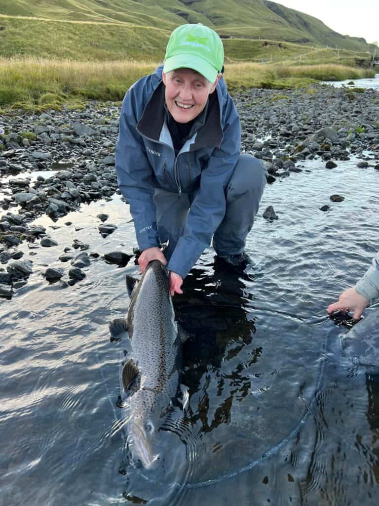 Vibrant rainbow trout caught during freshwater fishing adventure in scenic mountain river.