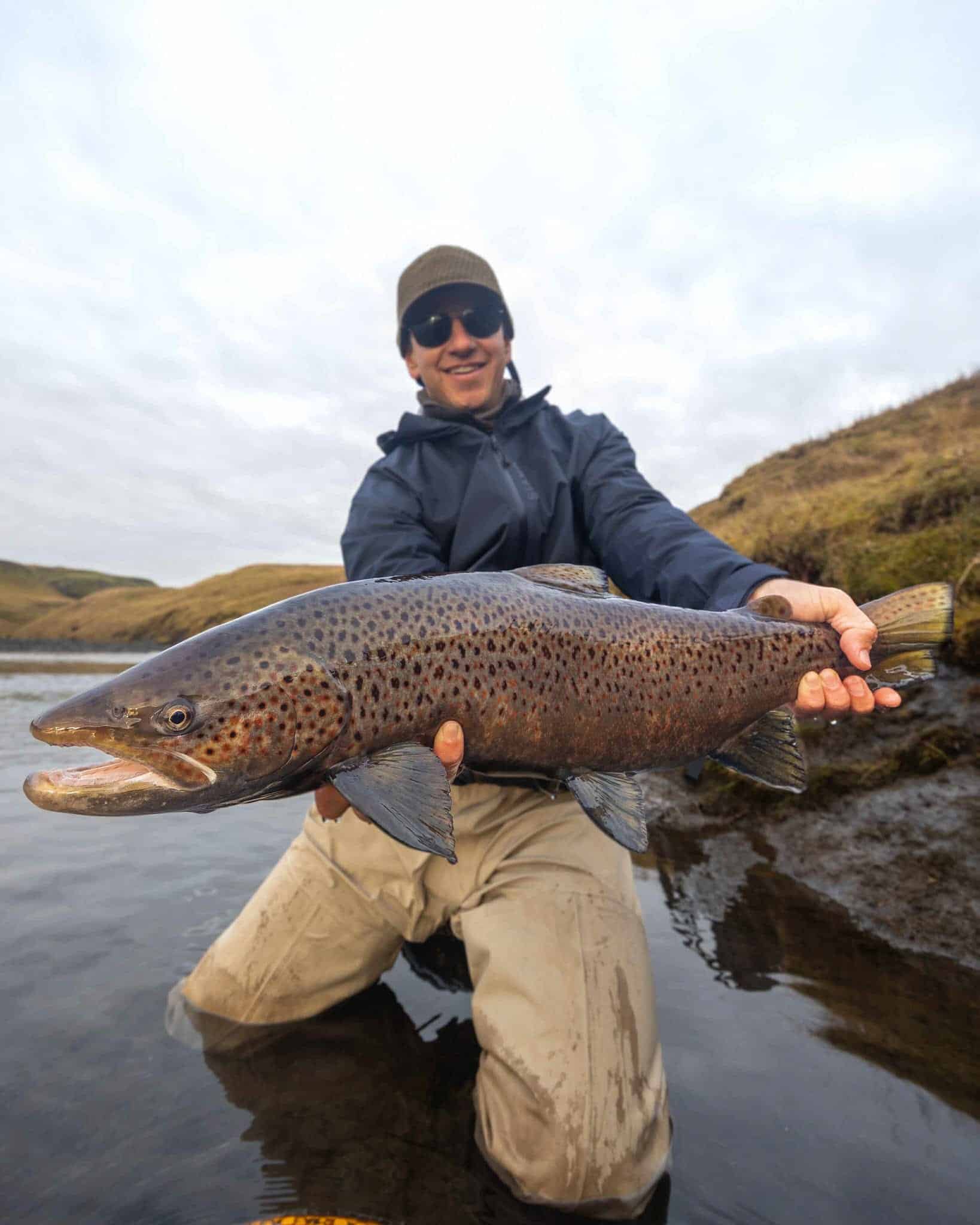 Biggest wild brown trout caught in the river. Beautiful catch for fishing enthusiasts and anglers.