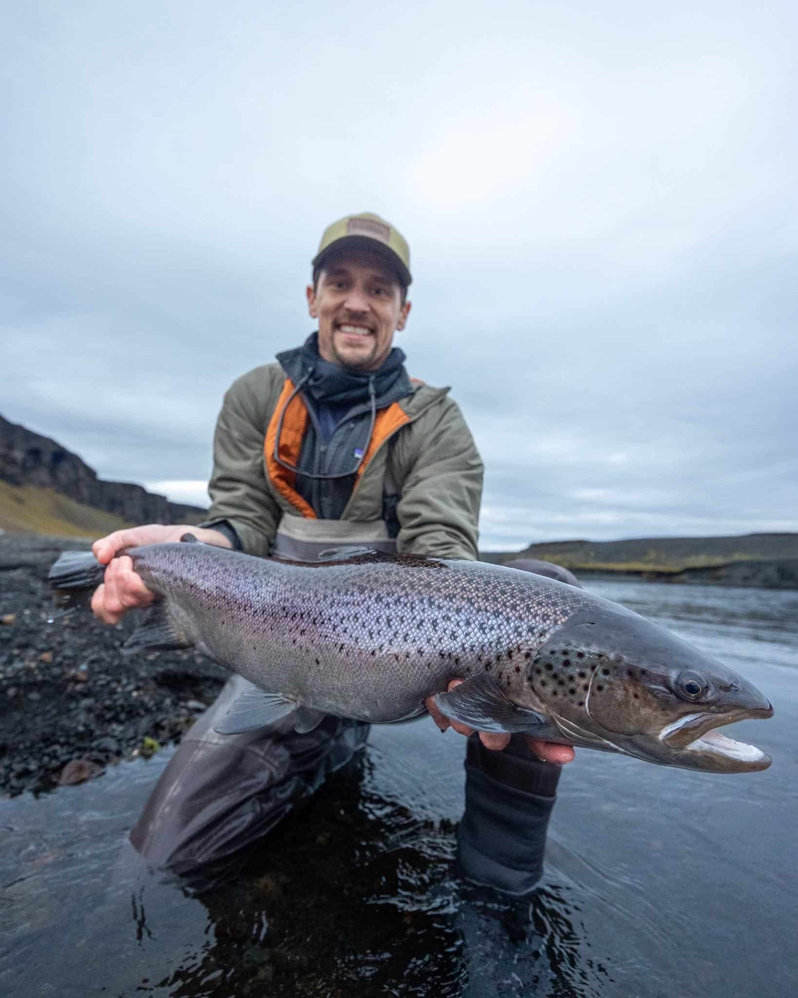 Large rainbow trout caught in scenic river fishing location - Fish Partner fishing apparel and equipment.