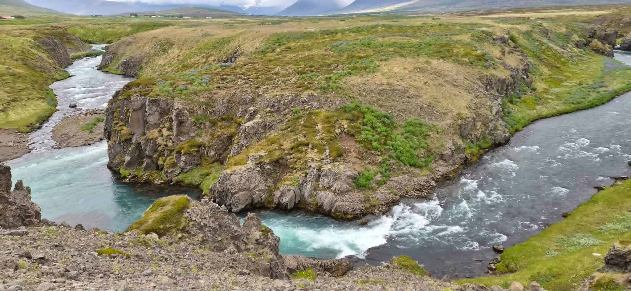 Wide view of a river flowing through a rugged canyon in Iceland.
