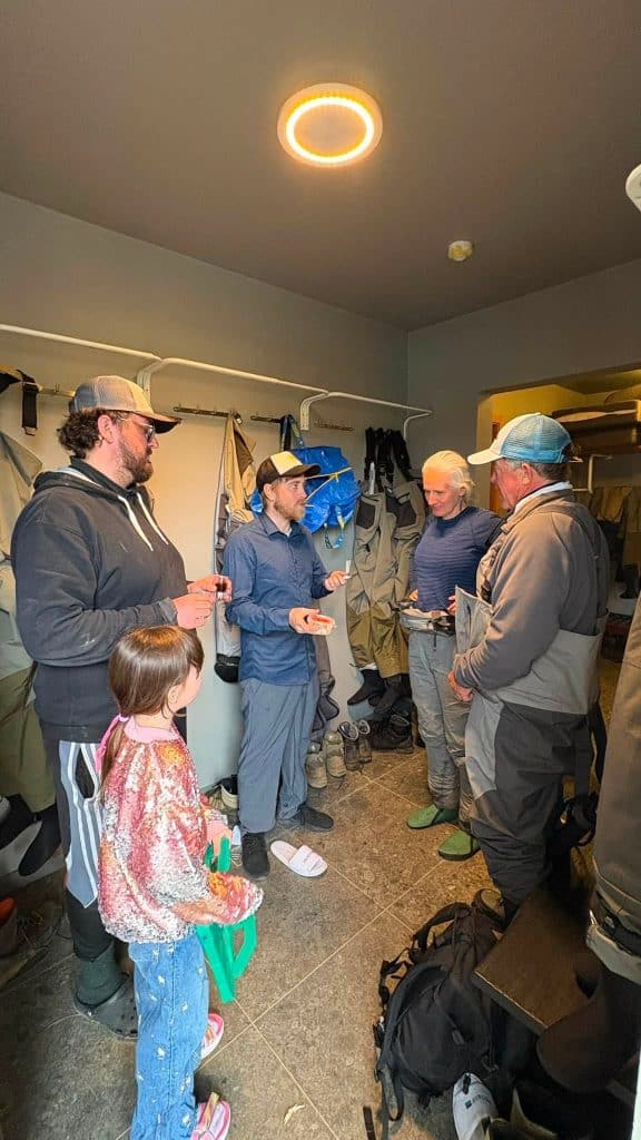 Group of people discussing fishing gear inside a tackle shop.