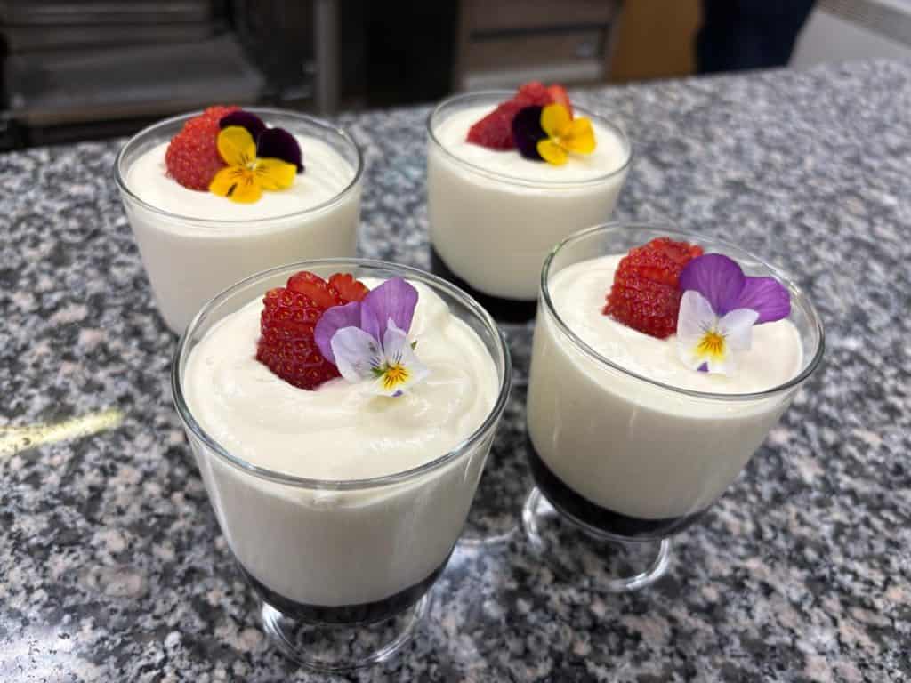Delicious fish-themed dessert with edible flowers in glasses.