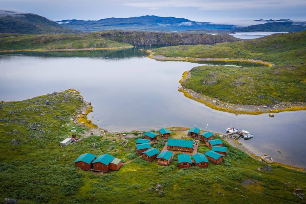 Aerial view of a remote fishing lodge by a lake in Greenland.
