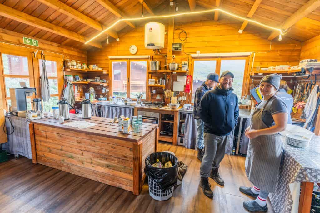 Warm wooden lodge interior with staff and guests preparing for fishing trip.