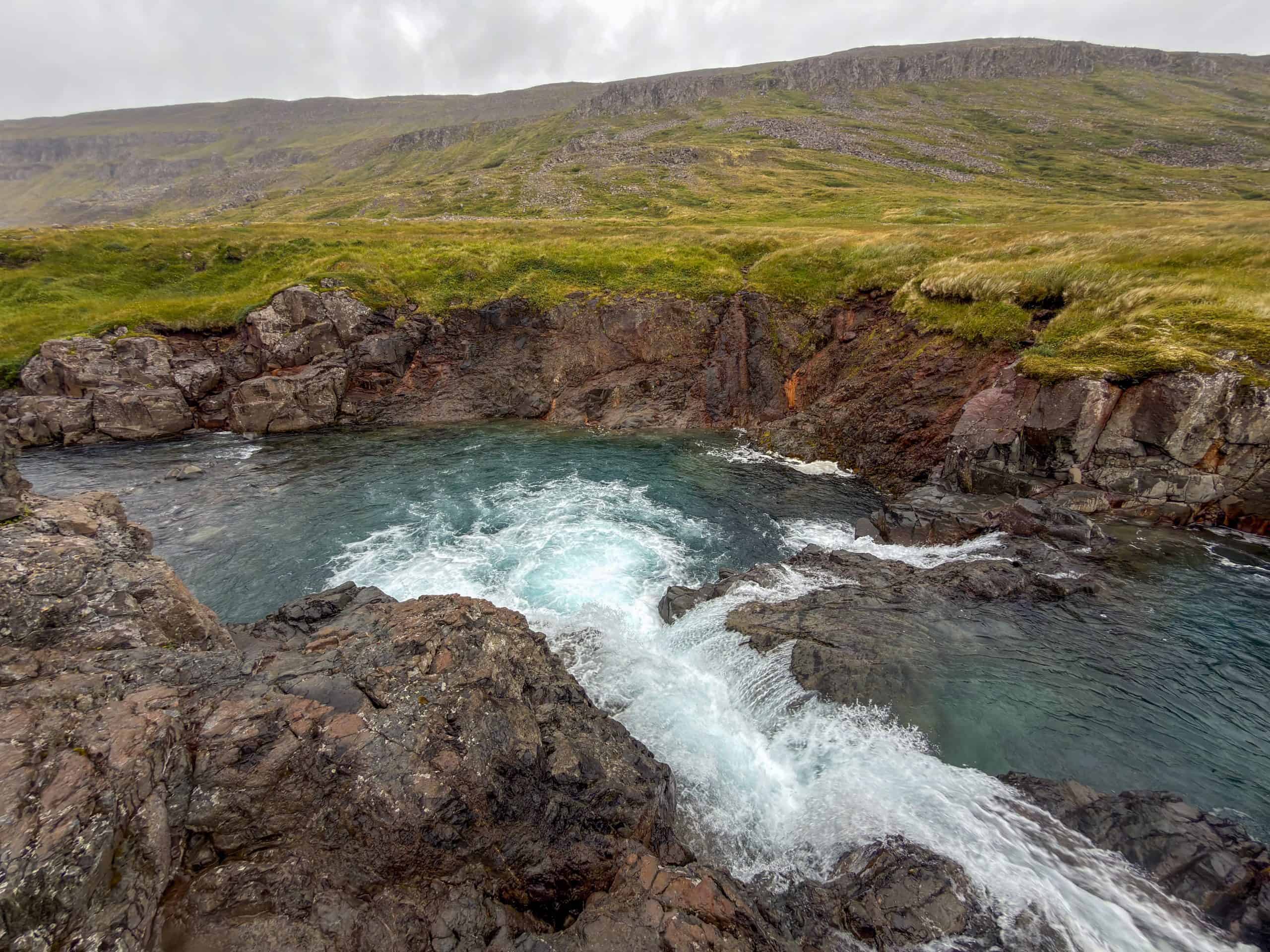 Scenic view of the clear river flowing through rocky landscape in Iceland.