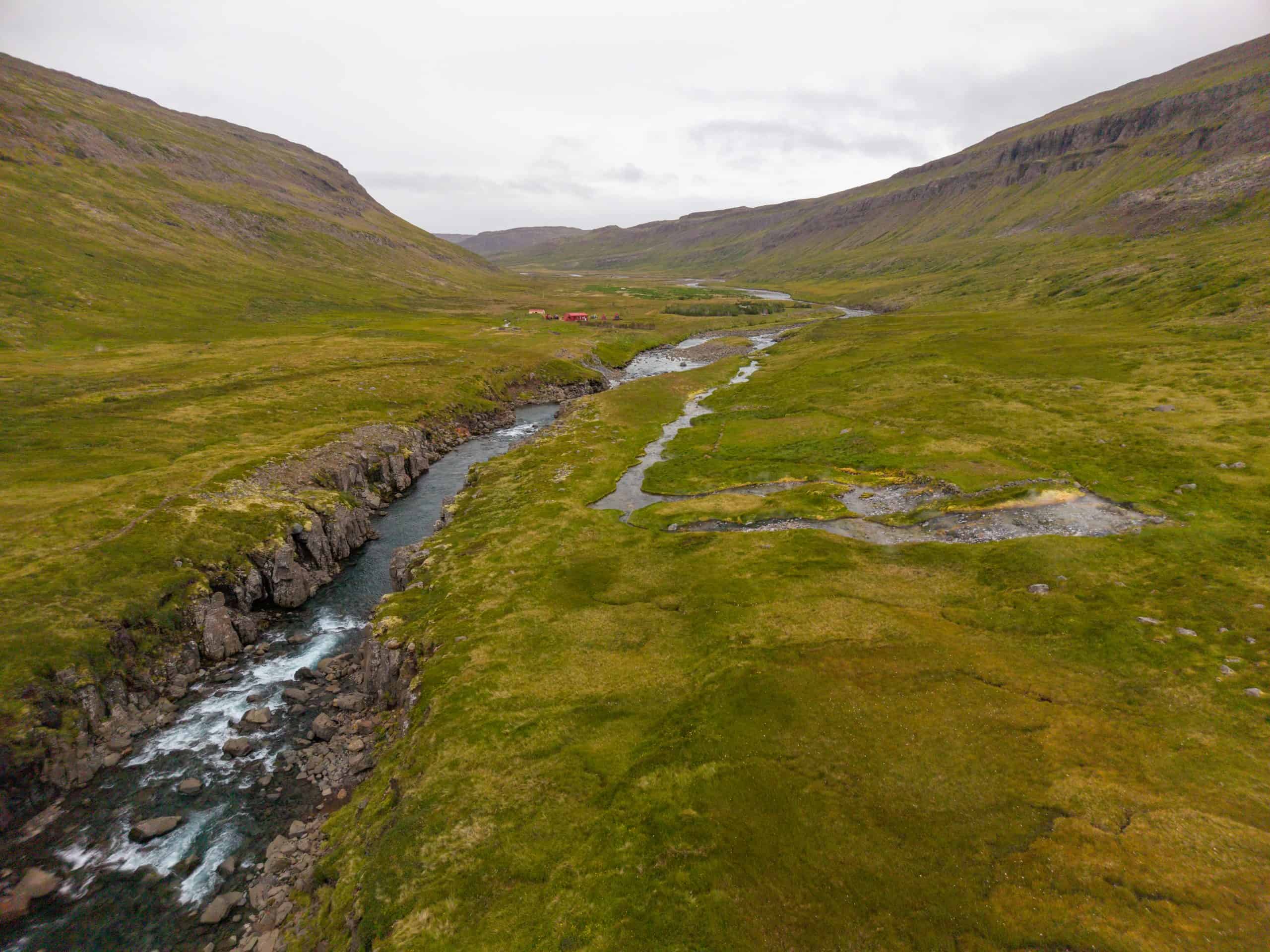Beautiful landscape of the Goðdalsá river flowing through lush green valley.