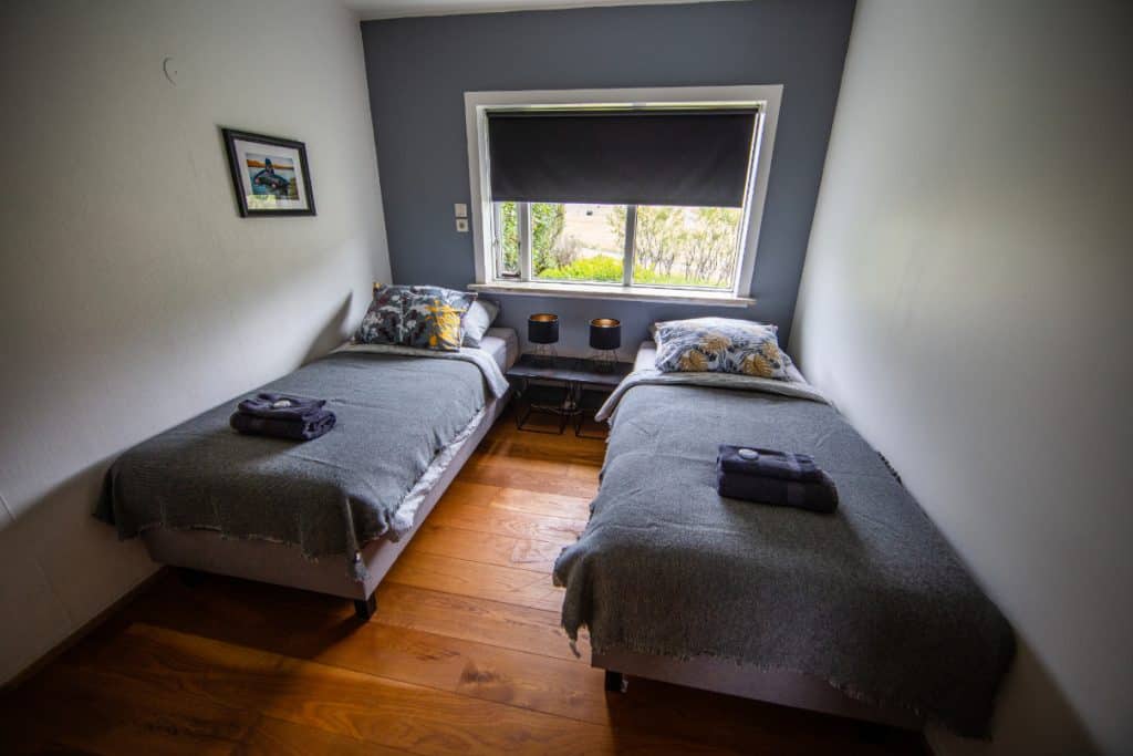 Twin bedroom with two beds, window, and minimal decor.