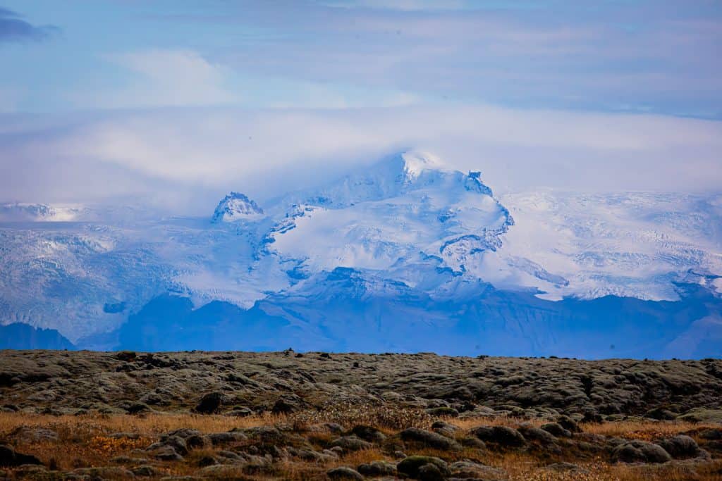 Majestic snow-covered mountains under a partly cloudy sky.