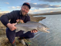 Flyfisherman holding a brown trout