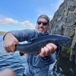Flyfisherman holding an arctic char