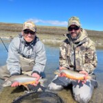 Two Flyfisherman holding an arctic char