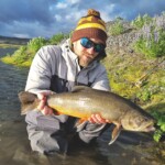 Flyfisherman holding an arctic char