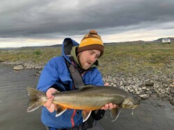 Flyfisherman holding an arctic char