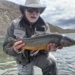 Angler holding a large fish he caught in Iceland's river, highlighting prime fishing conditions. Freshly caught fish from Iceland, showcasing high-quality freshwater fishing experience.