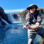 Flyfisherman holding an arctic char