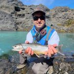 Man holds a large fish after successful fishing in Iceland's scenic landscape. Vibrant fish caught during an Icelandic fishing trip in clear blue waters. Perfect for fishing enthusiasts and adventure seekers.