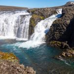 Scenic Icelandic waterfall with flowing water, rugged rocks, and vibrant surroundings, ideal for fish habitat and eco-friendly aquaculture. Crystal-clear waterfall in Iceland showcasing pristine freshwater and natural beauty.