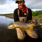 Fly fishing man holding a brown trout