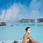 Visitors relaxing in a luxurious geothermal hot spring pool with scenic mountain views and therapeutic waters. Hot spring pool with steaming geothermal water and relaxing woman in spa setting.
