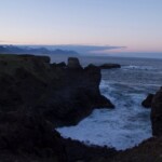 Stunning Icelandic coastline with cliffs and ocean during sunset, perfect for nature and travel enthusiasts. Rocky coastal cliffs and ocean waves at sunset, showcasing Iceland’s scenic rugged seaside landscape.