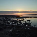 Scenic sunset at the coast highlighting aquaculture potential and marine ecosystem health. Sunset over rocky coastal waters, ideal for fish farming and aquaculture investment.