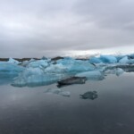 Spectacular Arctic scene with icebergs and glacial waters, showcasing the beauty and fragility of polar ecosystems. Melting icebergs floating in Arctic ocean under cloudy sky, environmental impact of climate change.