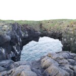 Sea arch formed by erosion on volcanic rocks near the ocean, offering scenic views for visitors. Rock formation with natural sea arch along rugged coastline, popular for fishing and sightseeing in Iceland.