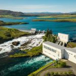 Hydropower facility generating clean energy amidst scenic nature with dam and water bodies. Hydropower dam and water reservoir in a lush green landscape, renewable energy source.