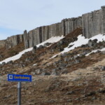 A mountainous area with rocky terrain and snow cover, featuring a Gerdüberg signpost, ideal for adventure and nature tourism. Scenic landscape of Gerdüberg mountain with rocky slopes and snow patches, popular for hiking and outdoor activities in Iceland.
