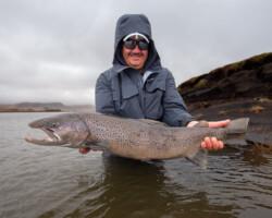 Large rainbow trout held by a smiling angler in Iceland's scenic landscape. Big rainbow trout caught while fishing in Iceland, showcasing high-quality freshwater fish from Fish Partner.